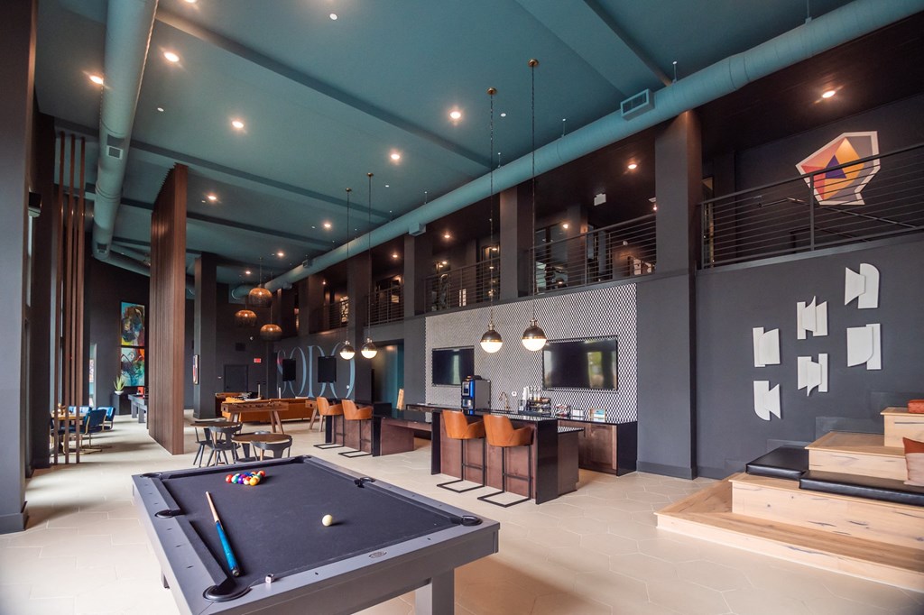 a game room with a pool table and a bar