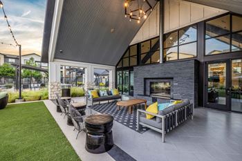 the outdoor patio of a home with furniture and a fireplace