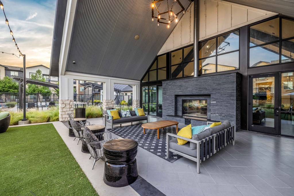 the outdoor patio of a home with furniture and a fireplace