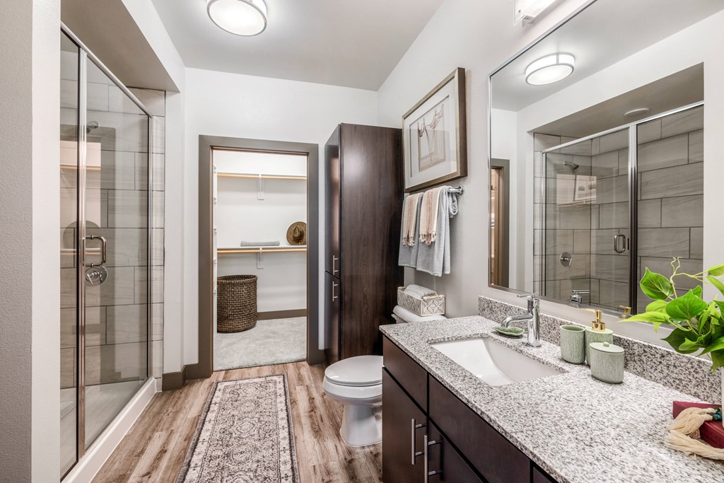 a bathroom with a shower and a sink and a toilet