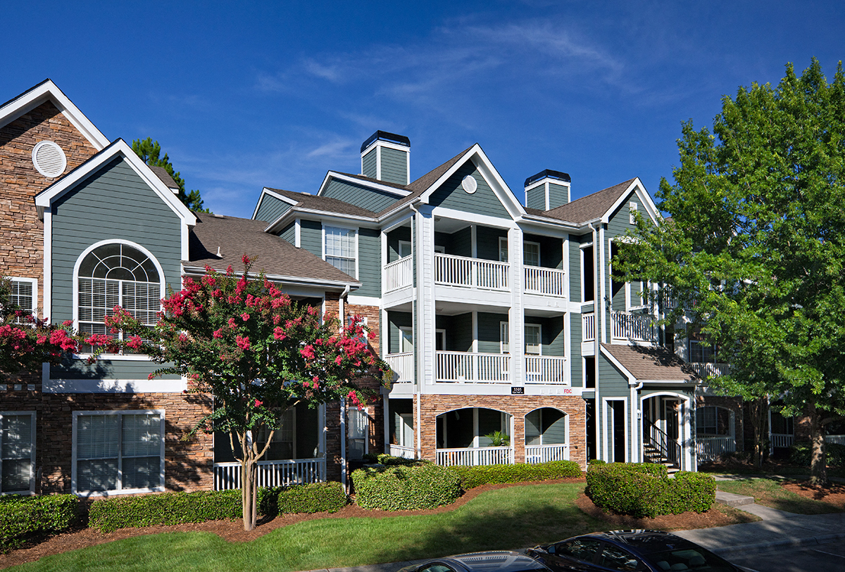 an apartment building with large balconies and trees