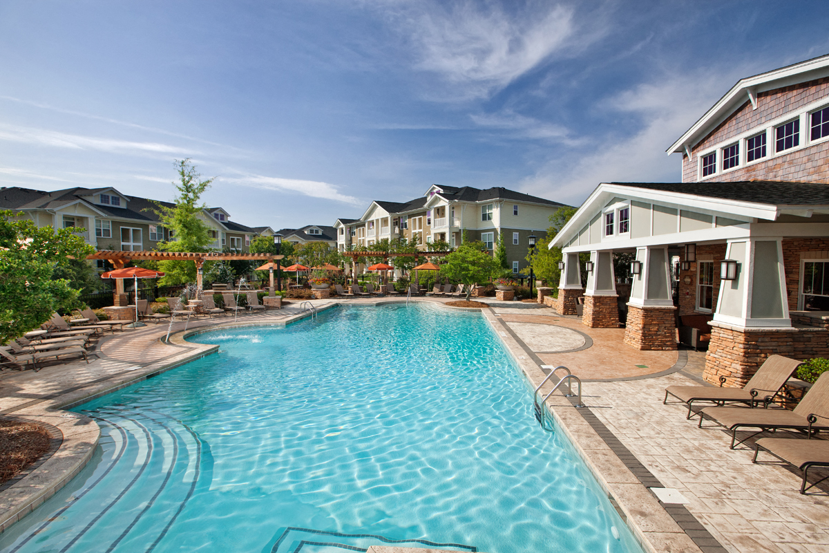 a large swimming pool with houses in the background
