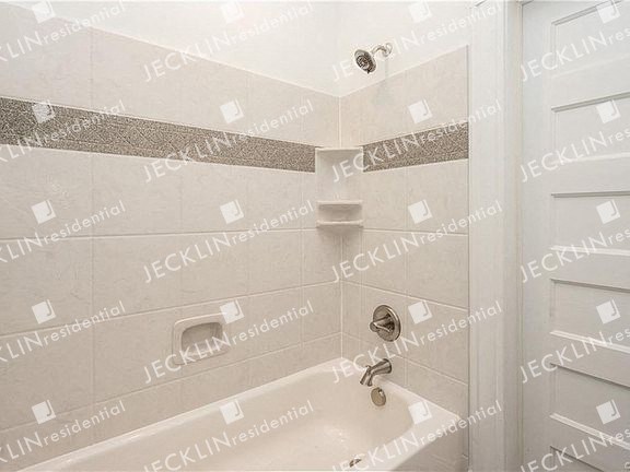 a white bath tub sitting next to a white door