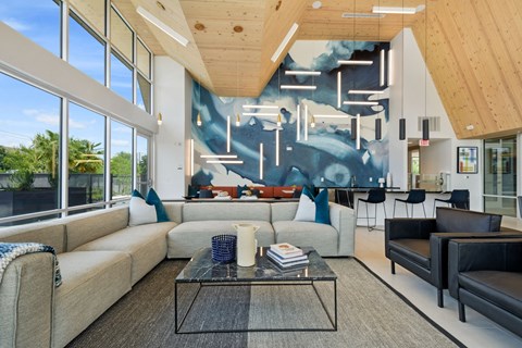 a living room with couches and a coffee table in front of a large mural