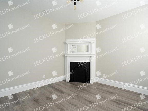 a empty room with a fireplace and a chandelier