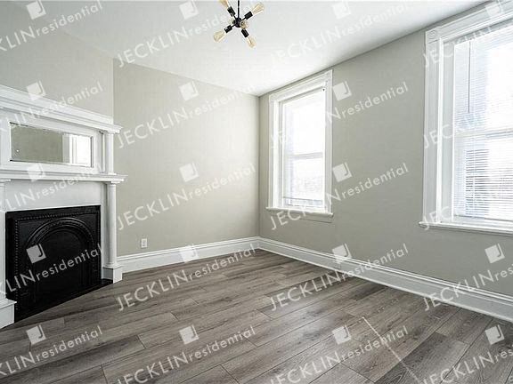 a empty room with a fireplace and two windows