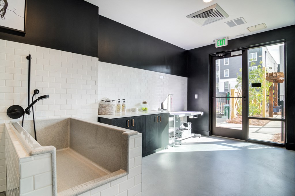 a kitchen with a sink and a tub and a door to a surgery room