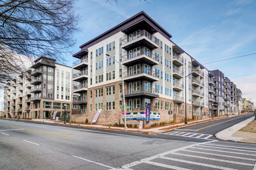 a large apartment building on the corner of a city street