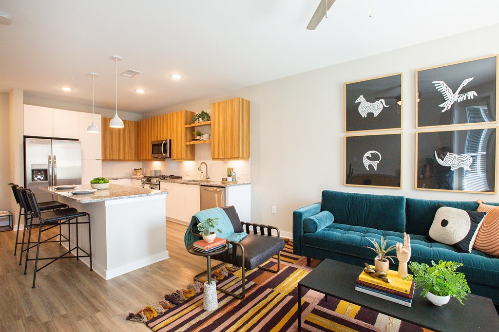 a living room with a blue couch and a kitchen with an island
