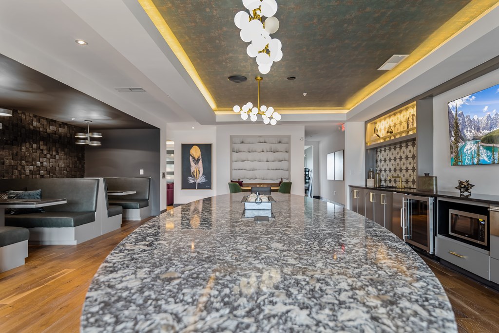 A modern kitchen with a marble island in the center.