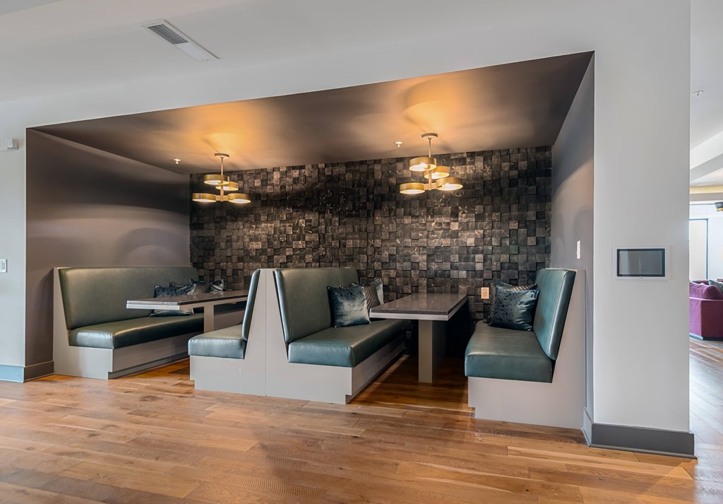 A modern waiting room with a stone wall and leather chairs.