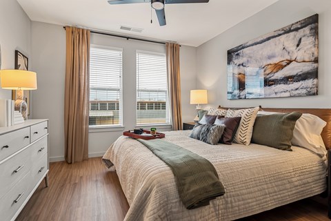 A bedroom with a large bed and a ceiling fan.