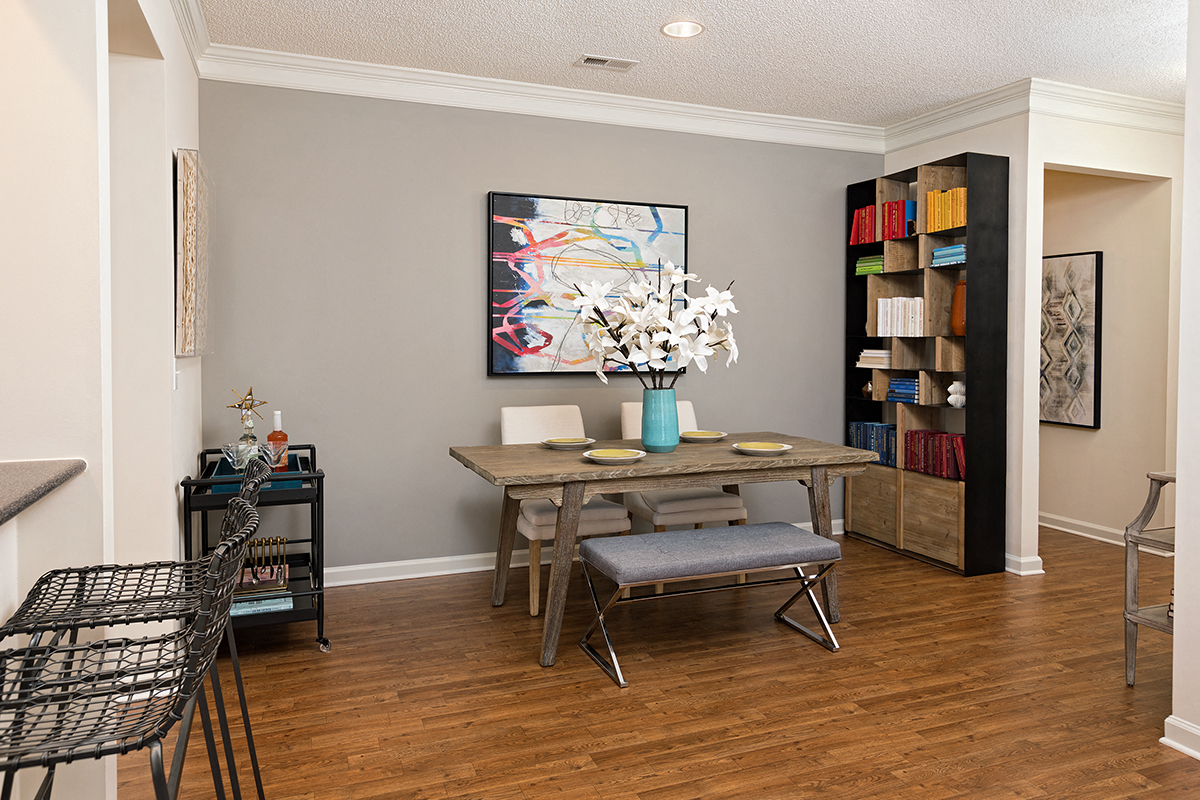 a dining room with a table and chairs and a bookcase