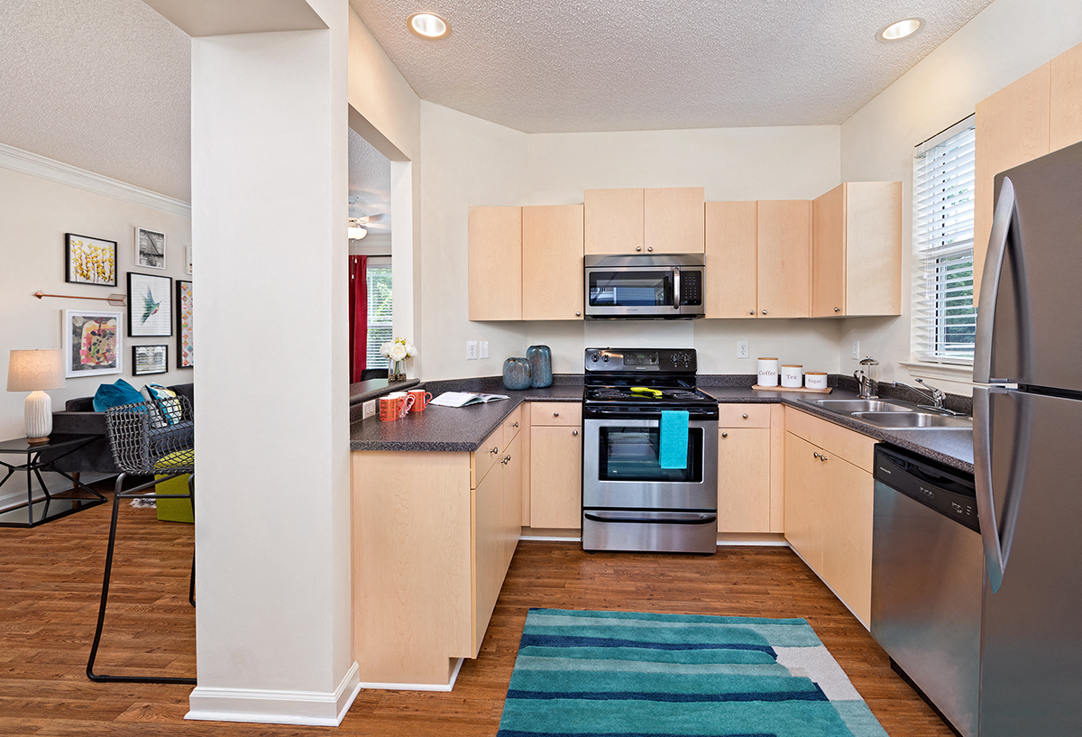 a renovated kitchen with stainless steel appliances and wooden floors
