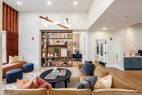 a living room with couches and a coffee table in front of a book shelf