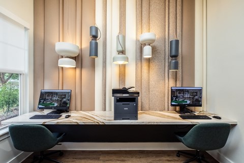 a desk with two computers and three monitors on it