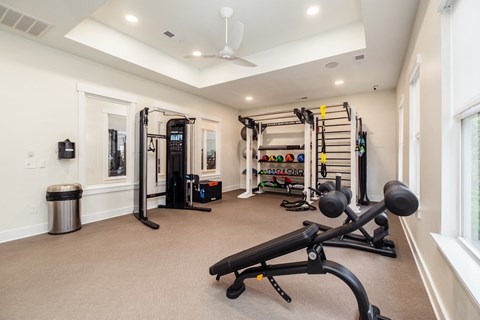 a home gym with exercise equipment and a ceiling fan