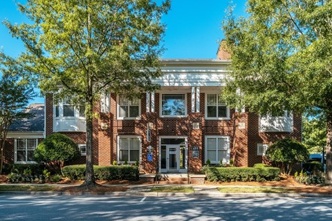A red brick building with a white door and windows.
