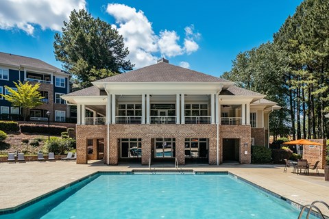 A large building with a pool in front of it.
