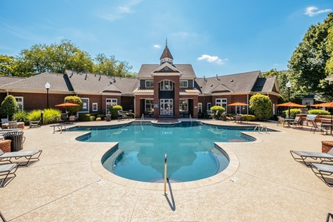 A large swimming pool in front of a house.