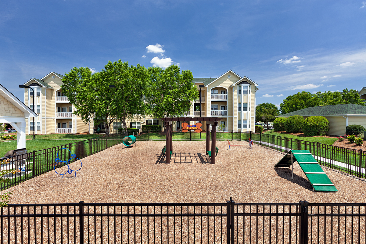 a playground with a swing set in front of an apartment building