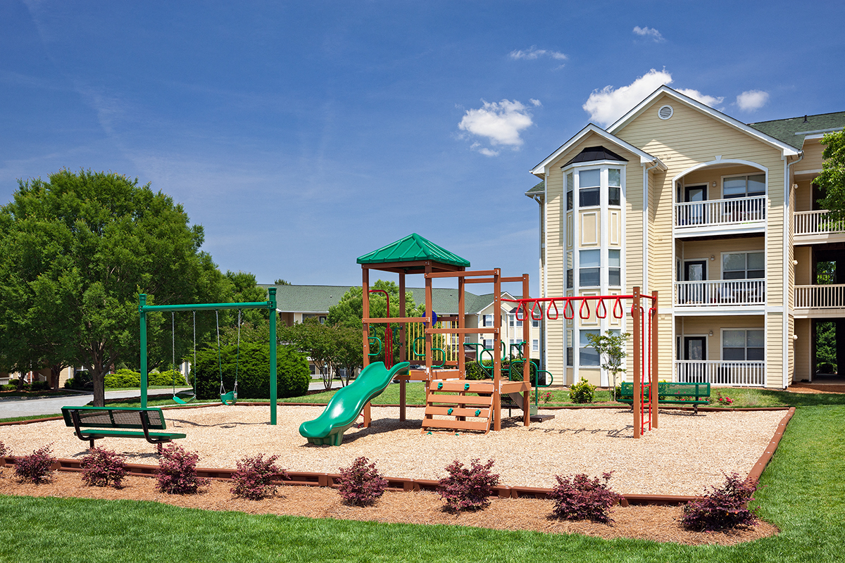 a playground in front of an apartment building