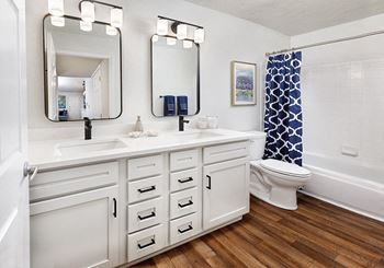 A bathroom with a white sink and a white toilet.