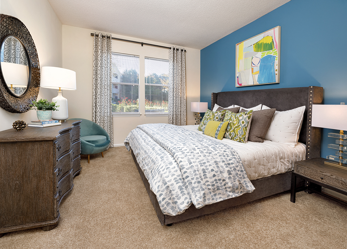 a bedroom with blue walls and a bed with pillows