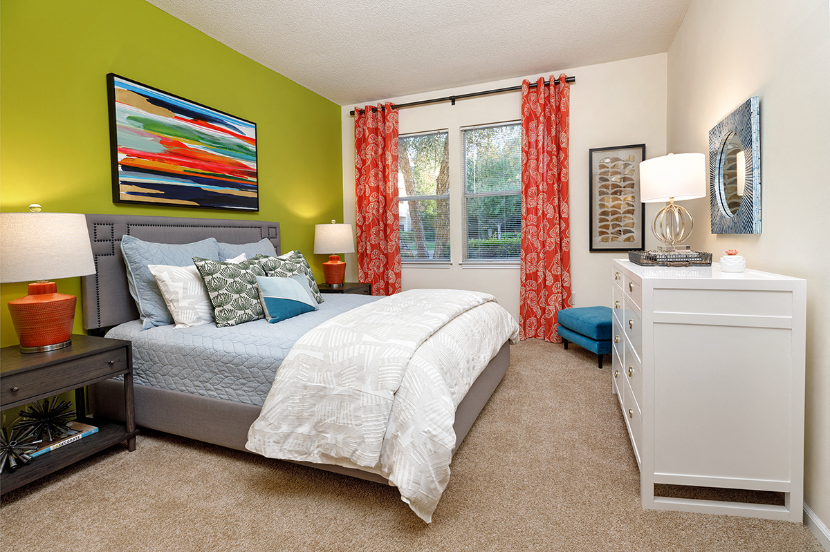 a bedroom with a bed and a dresser and a window