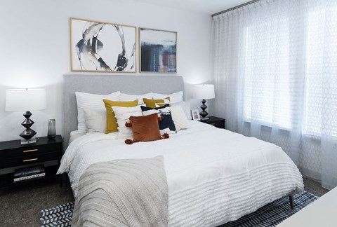 a bedroom with a large bed with white sheets and pillows
