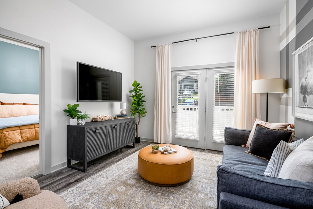 a living room with a tv and a door that leads to a bedroom