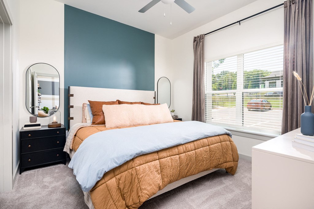 a bedroom with a bed and a dresser with a mirror