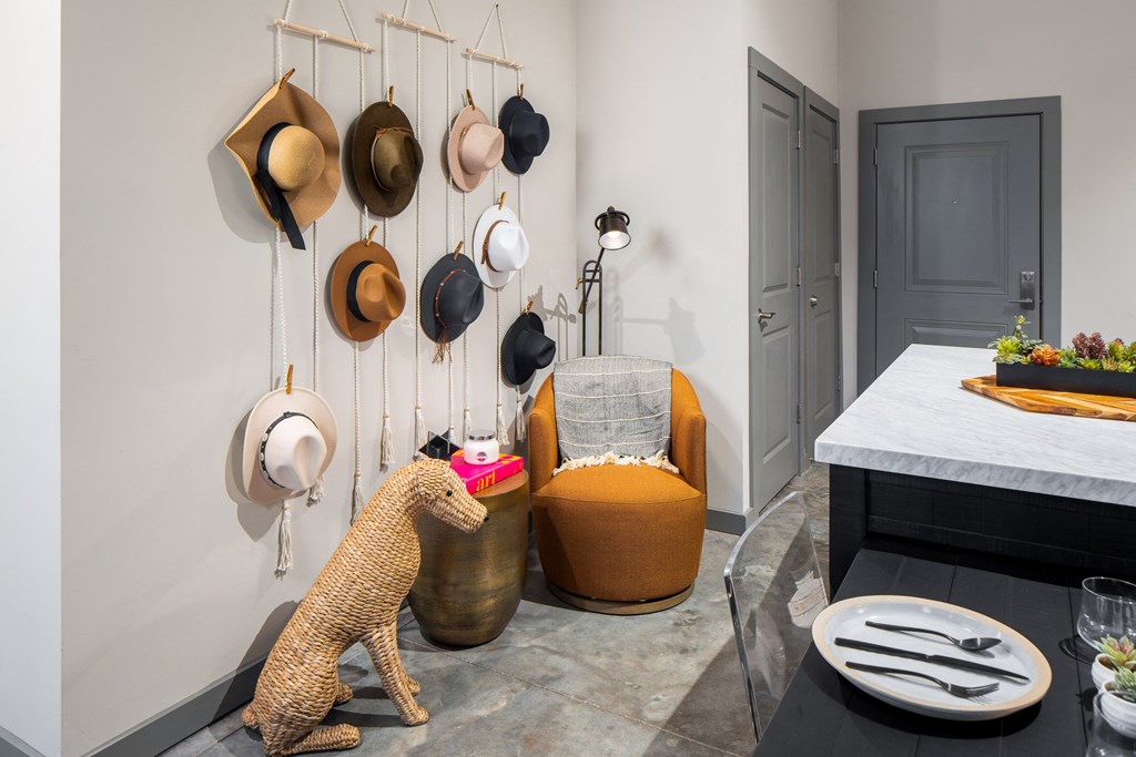 a selection of hats hangs from the wall in the entry of the apartment