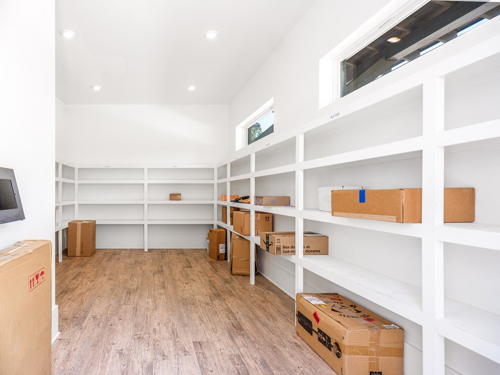 a room with white shelves and boxes on it