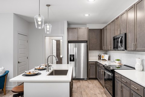 A modern kitchen with a stainless steel refrigerator and wooden cabinets.
