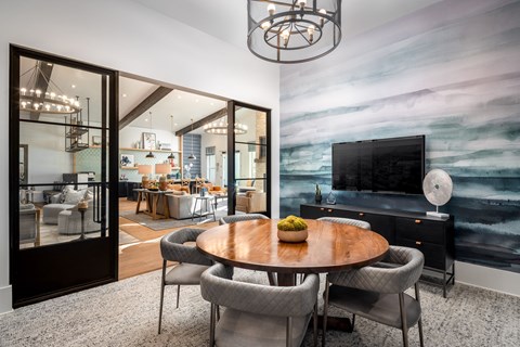 A modern dining room with a wooden table and grey chairs.