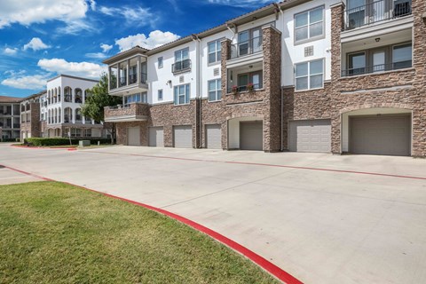 A row of modern apartment buildings with garages and a red line on the ground.