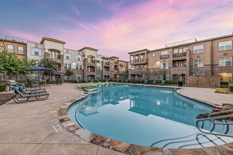 a swimming pool with an apartment building in the background