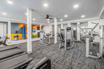 a gym with treadmills and other exercise equipment in a building with white ceilings