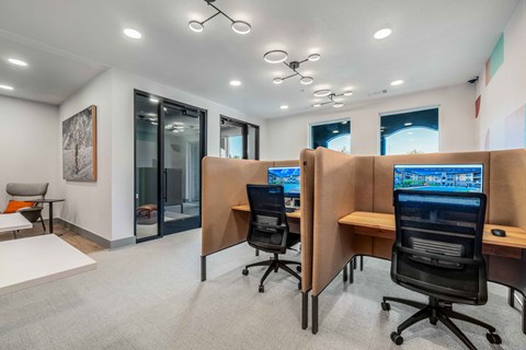 two computer desks and chairs in a room with a large window