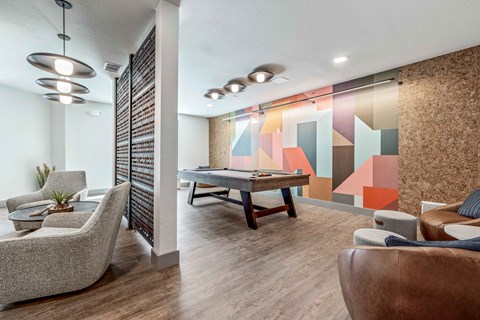 a game room with a pool table and couches