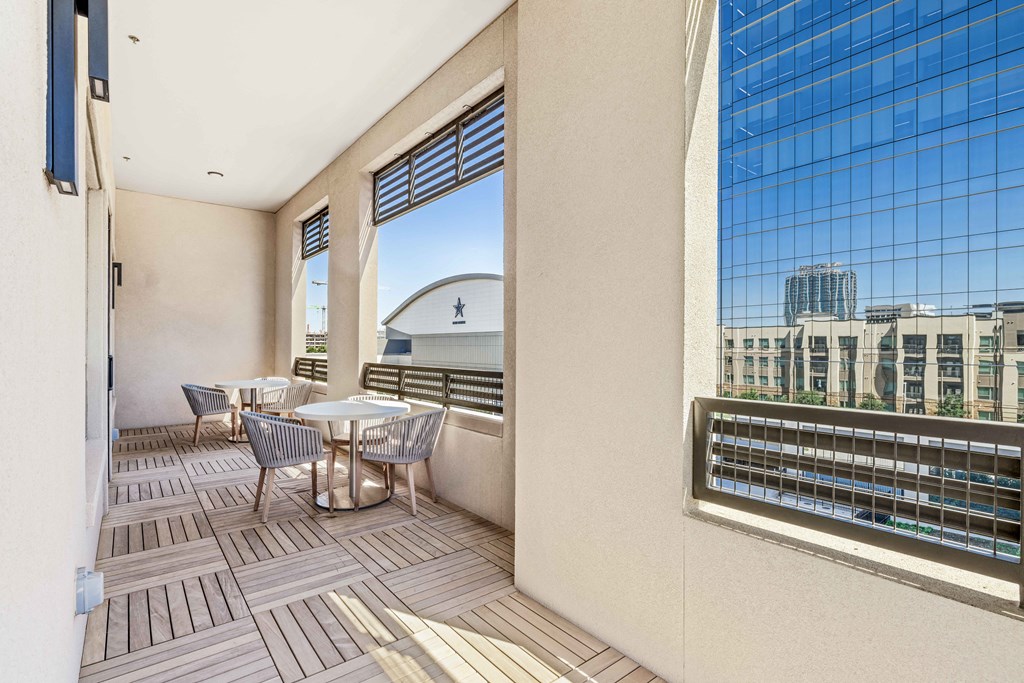 a balcony with tables and chairs and a view of a city