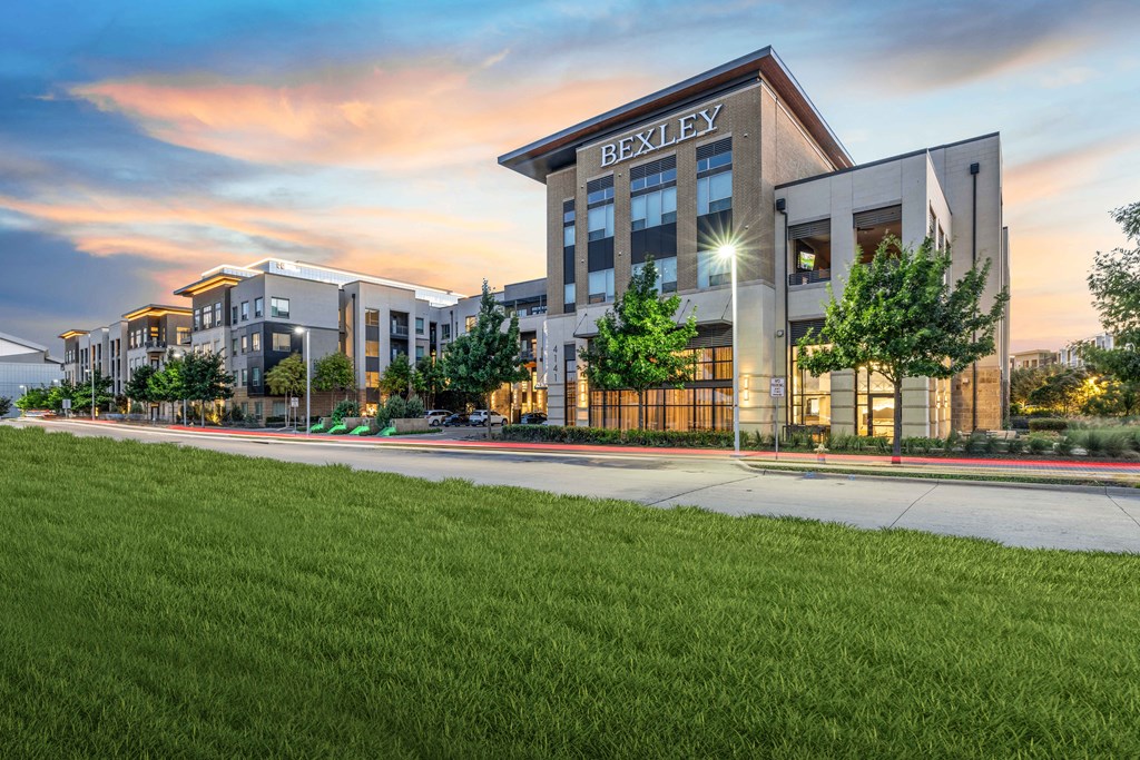 an exterior view of a building with green grass and a sidewalk