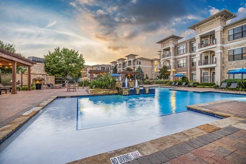 a large swimming pool with an apartment building in the background