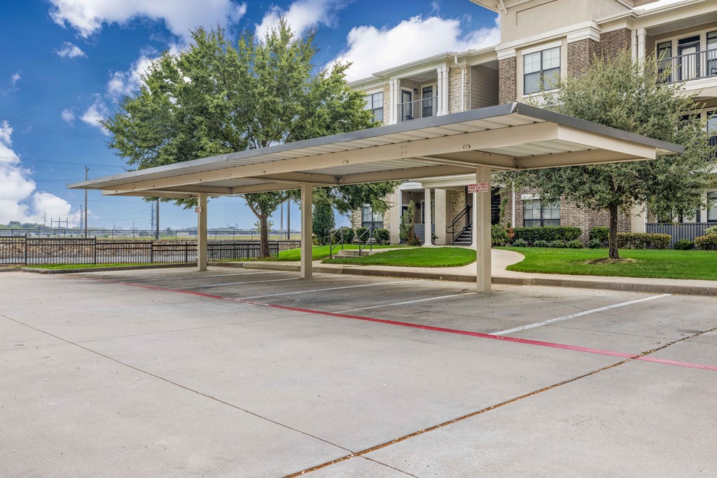 a covered parking lot in front of an apartment building