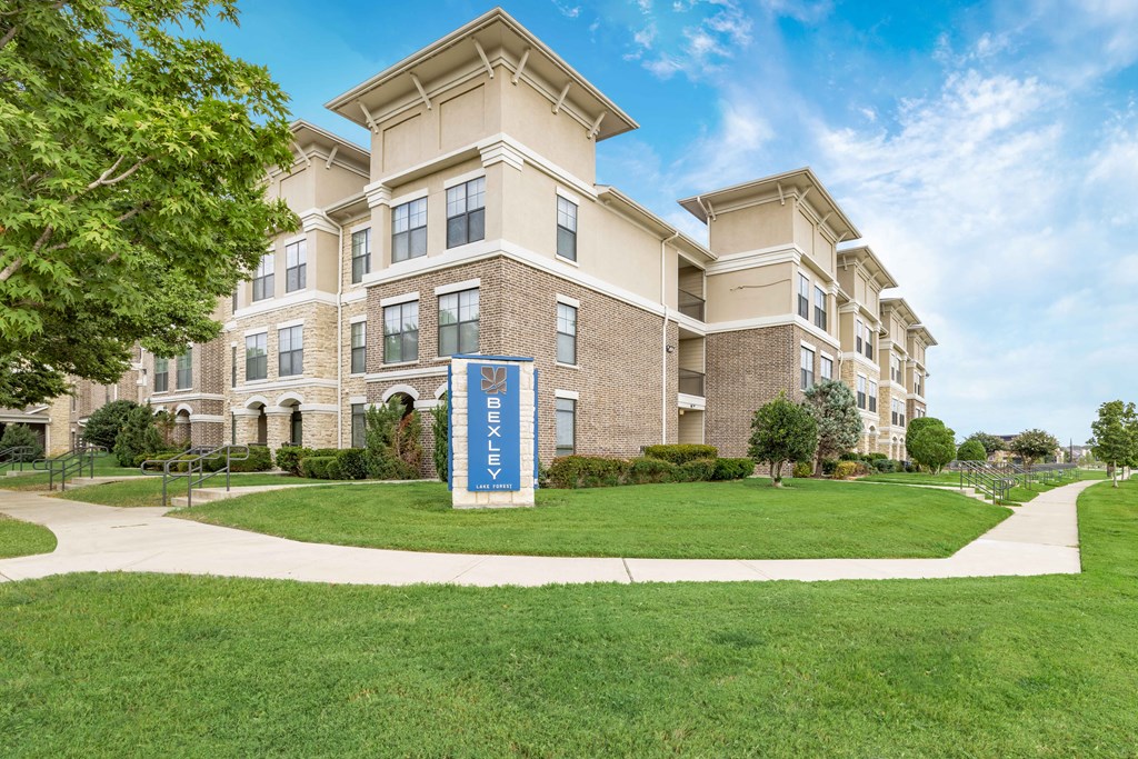 an apartment building with a blue sign in front of it