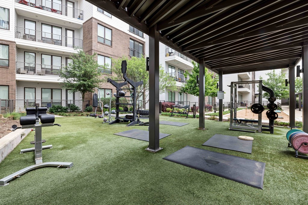amenities including a fitness center with weights and cardio equipment on the grass