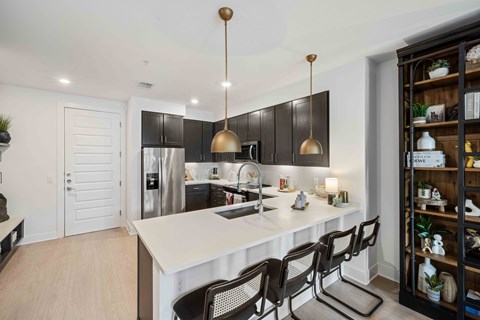 a kitchen with a white counter top and black cabinets