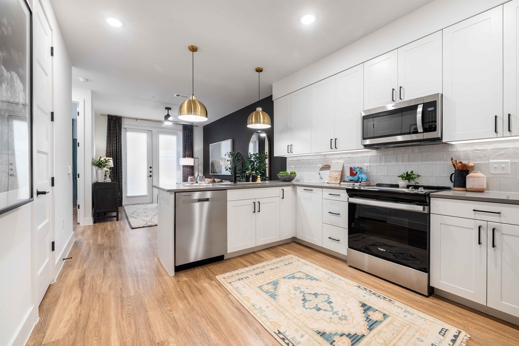 a large kitchen with white cabinets and stainless steel appliances