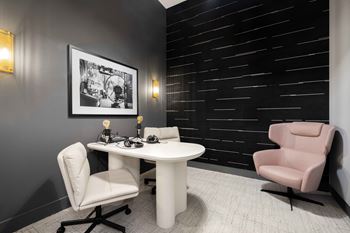 a small office with a pink chair and a white desk